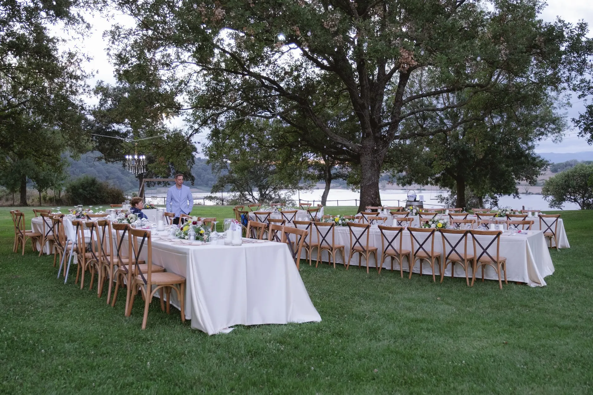 An imperial banquet table set under the great oak at Frà Viaco, with Lago di Mezzano beyond