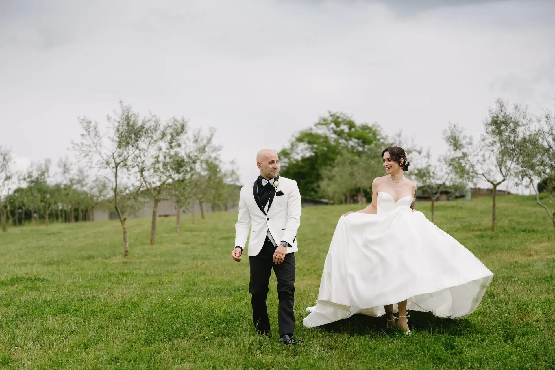 The newlyweds running happily across the lawn at a real wedding at Frà Viaco