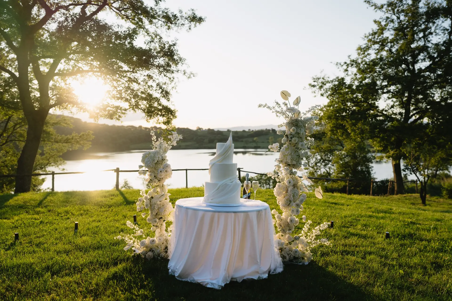 The wedding cake at sunset with Lago di Mezzano in the background, at a real wedding at Frà Viaco